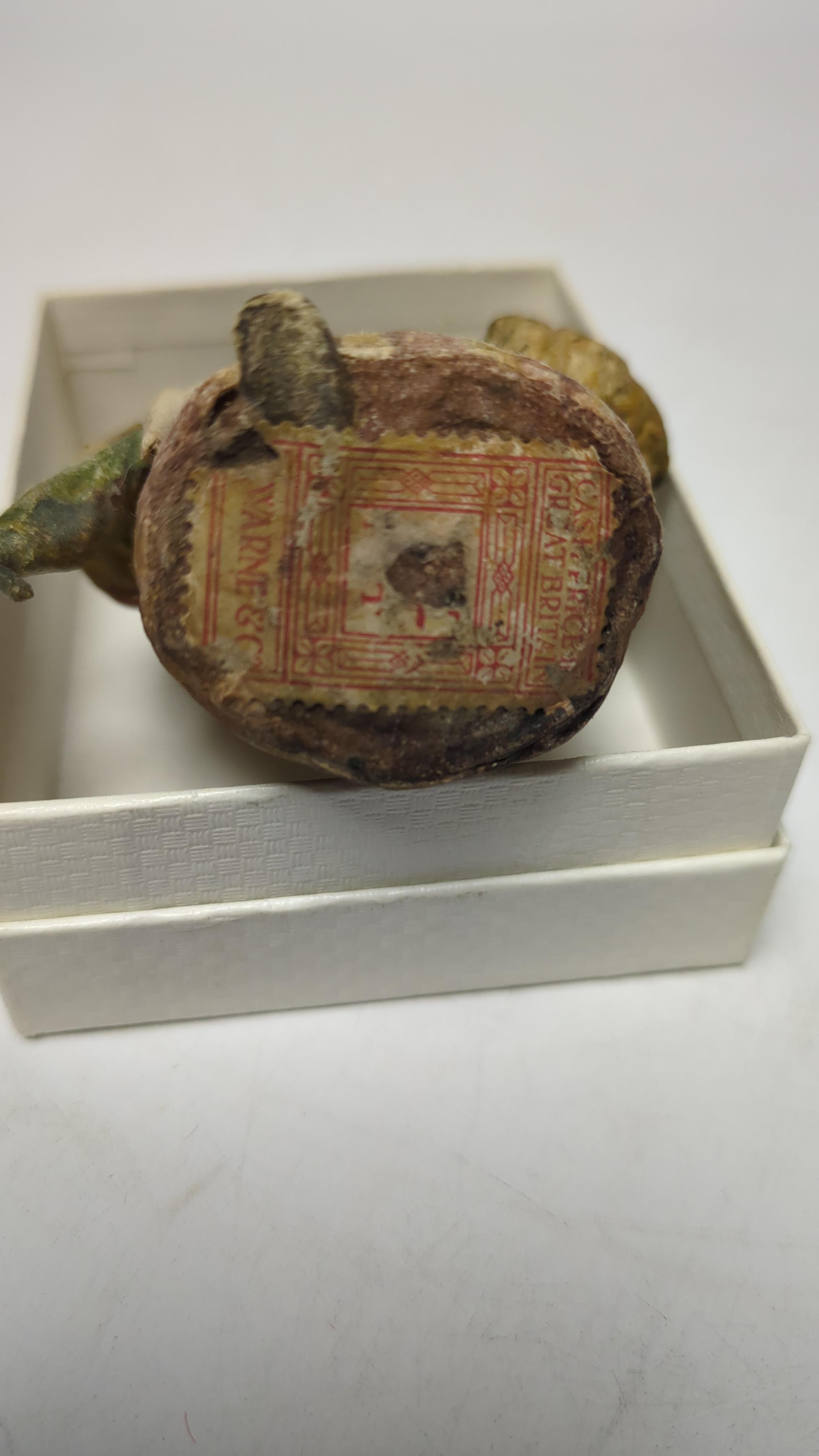 An F. Warne papier-mâché Beatrix Potter figure of Mrs. Rabbit with basket and umbrella, red and white F. Warne & Co. paper label to the base, dating it to pre-1917, 8.5cm high